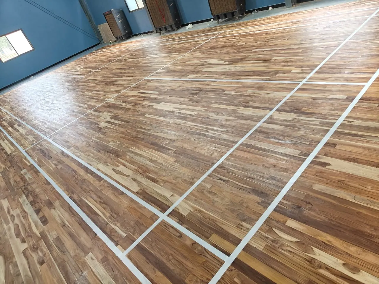 Wooden indoor court with white badminton lines